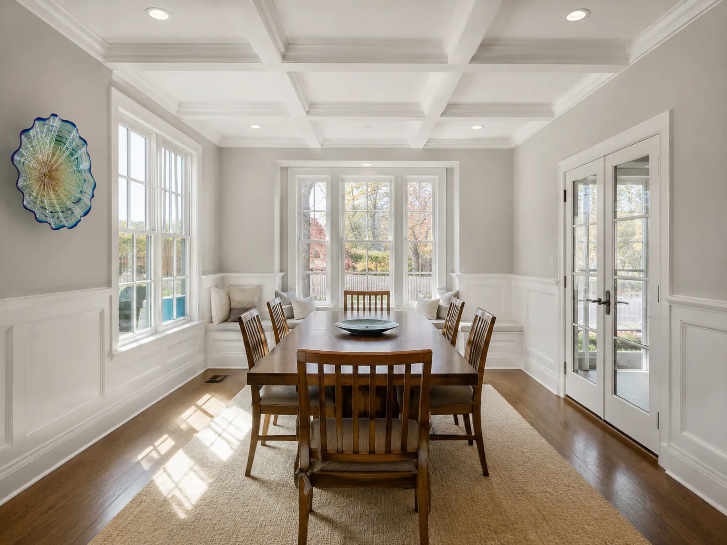 Completed dining room with painted paneling, detailed trim, and a coffered ceiling
