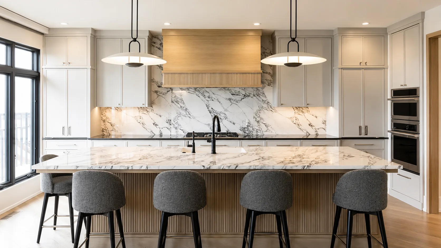 Finished gray kitchen cabinetry with a fluted island, wood hood, and stone surfaces