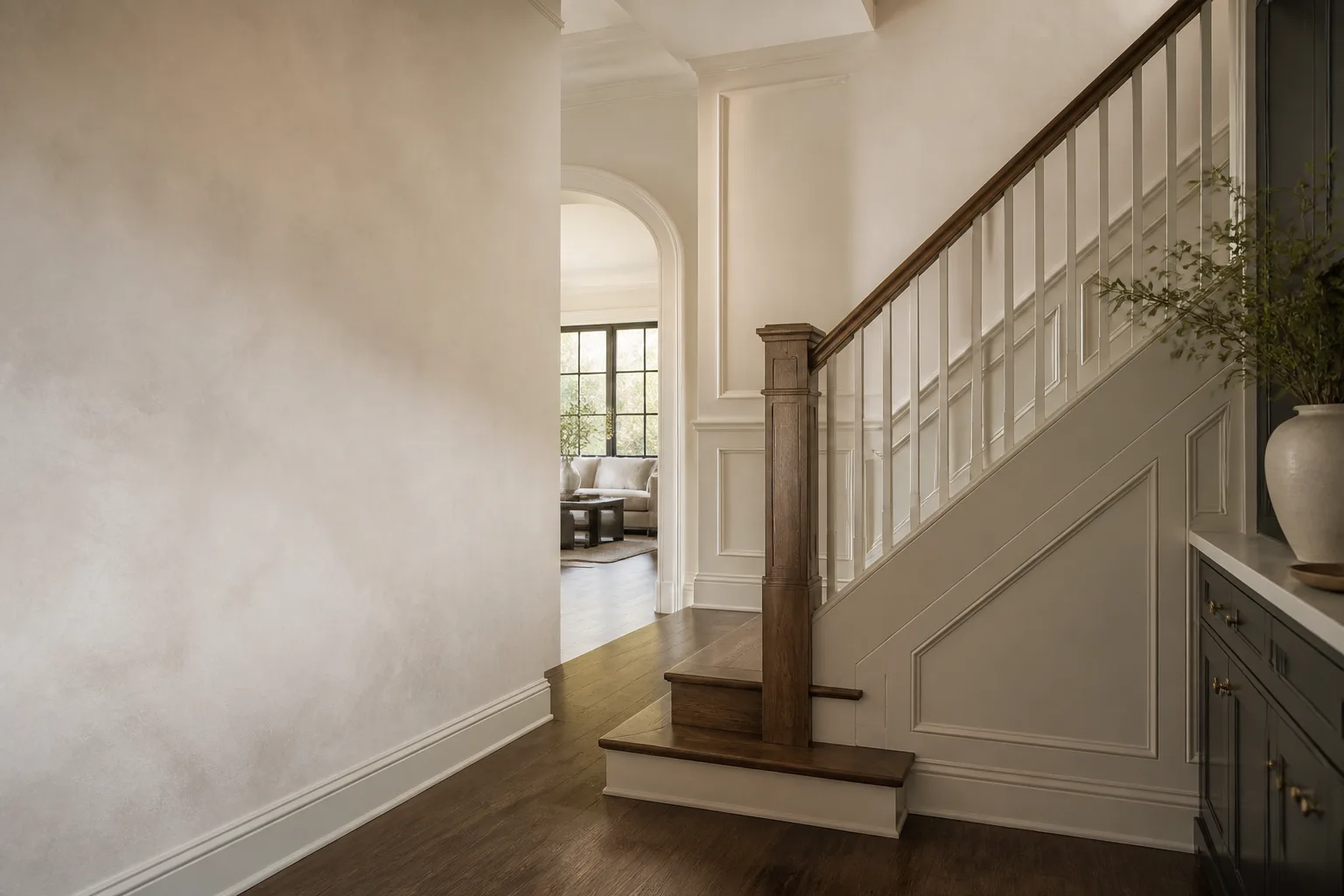 Stair hall with layered wall color, painted trim, paneling, and stained wood
